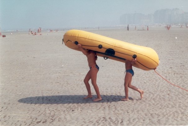 kinderen onderen rubberen bootje op het strand, op weg naar de zee