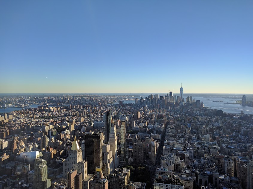 Zicht op One en Vrijheidsbeeld vanuit Empire State Building
