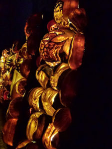 Zij-aanzicht superman met gigantische pompoen als borstkas