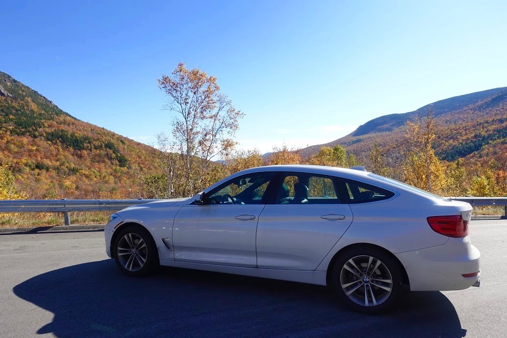 Witte BMW auto met op de achtergrond de indrukwekkende White Mountains in NH, tijdens de herfstrit