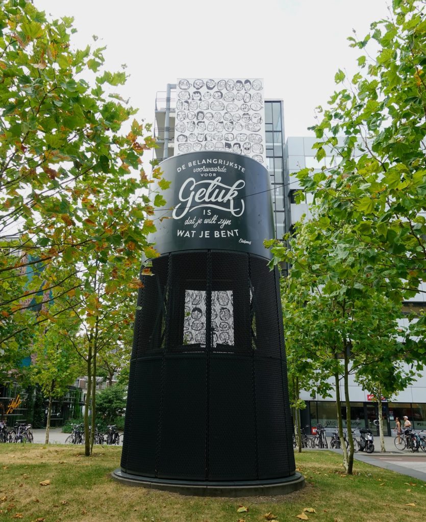 "De belangrijkste voorwaarde voor GELUK is dat je wilt zijn wat je bent." Erasmus, mural in Rotterdam op Stationsplein