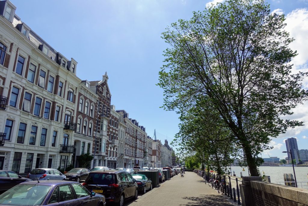 Noordereiland in Rotterdam, oude woningen aan de Maaskade, zicht op water en in de verte de Erasmusbrug