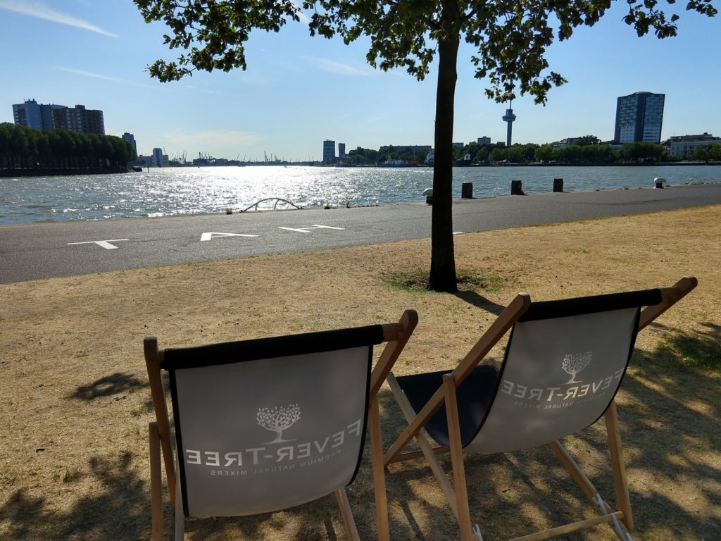 Strandstoelen op de Wilhelminapier met zicht op de Nieuwe Maas en Euromast in Rotterdam