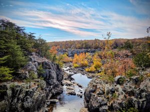 Herfst tafereel: stromend water, rotsen en zowel kleurrijke herfstbomen als groene naaldbomen, blauwe lucht: Great Falls Park